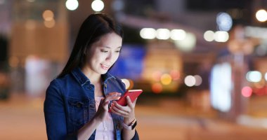 Kadın stand yolun ve geceleri cep telefonu kullanma