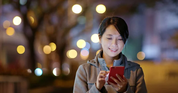Woman using mobile phone online at night