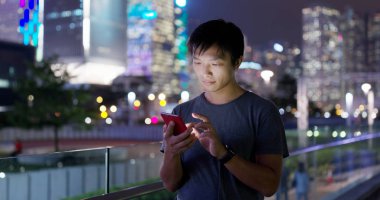 Adam cep telefonuyla şehirde geceleri