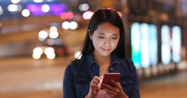 Geceleri cep telefonu kullanan kadın