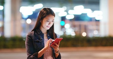 Kadın iş üstünde hareket eden telefon City geceleri