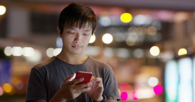 Sokakta cep telefonu kullanan bir adam.