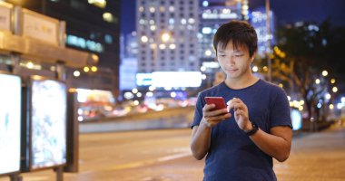 Geceleri cep telefonu kullanan adam