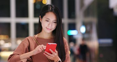 Plaza alışveriş içinde cep telefonu kullanan kadın