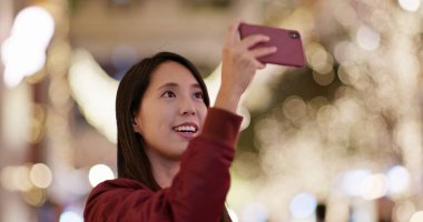 Kadınlar gece yılbaşı ağacı süslemesinde fotoğraf çekerler.