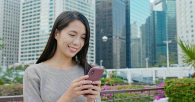 Şehirde akıllı telefon kullanan bir kadın