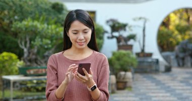 Kadın iş üstünde hareket eden telefon içinde şehir parkı