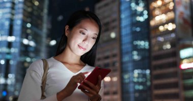 Kadın iş smartphone cep telefonu ile şehir içinde geceleri