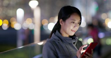 Kadın iş üstünde hareket eden telefon City geceleri