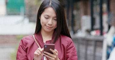 Akıllı telefon kullanan genç bir kadın.