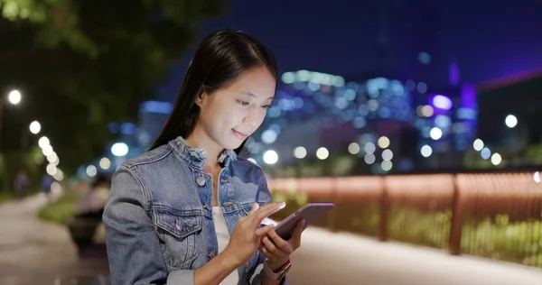 Woman using mobile phone online at night