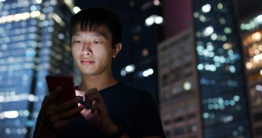 Smartphone şehirde geceleri kullanan adam