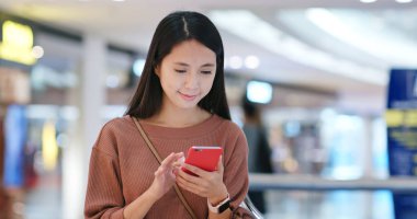 Alışveriş Merkezi içinde cep telefonu kullanan kadın