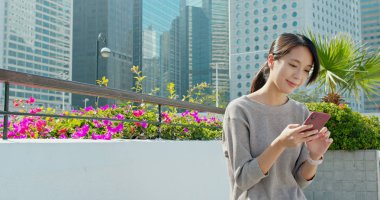 Şehirde akıllı telefon kullanan bir kadın