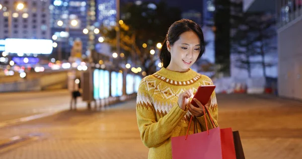 Woman Using Mobile Phone Holding Shopping Bags Night — Φωτογραφία Αρχείου