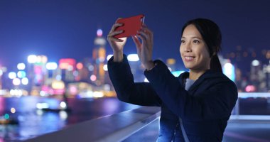 Kadın geceleri cep telefonundan fotoğraf çekmek