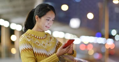 cep telefonuyla şehirde gece kadın