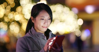 cep telefonuyla şehirde gece kadın