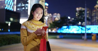 Kadın bak cep telefonu City alışveriş çantası ile geceleri