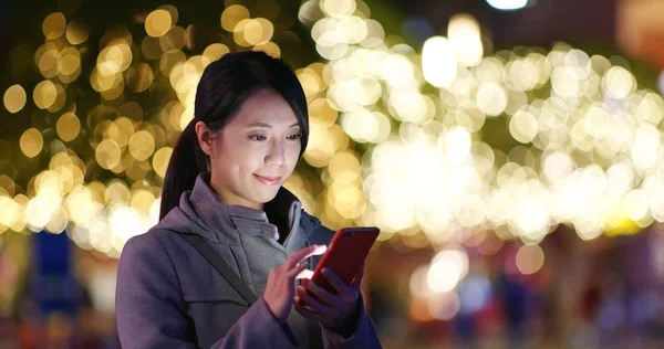 Woman using mobile phone with golden light