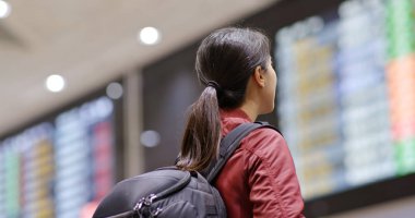 Young woman look at the flight number in the airport