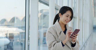 Havaalanında cep telefonu kullanan kadın