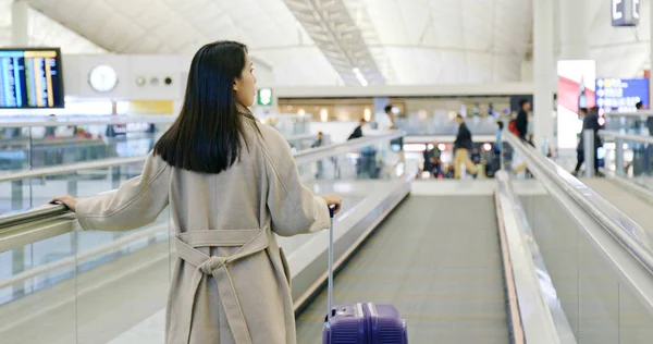 Woman walking in the airport with her luggage