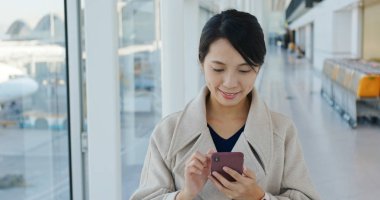 Havaalanında cep telefonu kullanan kadın