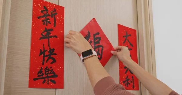 女人把中国书法贴在家里 — 图库照片