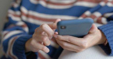 Evde cep telefonu kullanan bir kadın