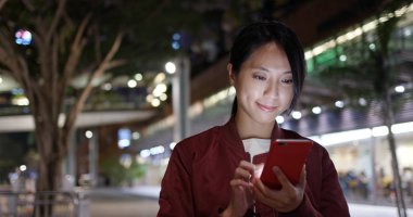 Kadın gece şehirde smartphone cep telefonu ile kontrol