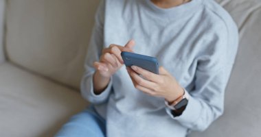 Evde cep telefonu kullanan Asyalı kadın.