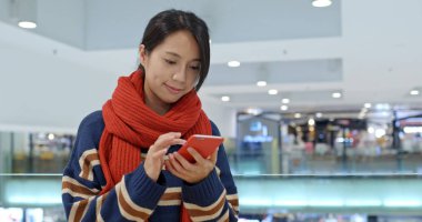 Alışveriş merkezinde cep telefonu üzerinde iş kadın