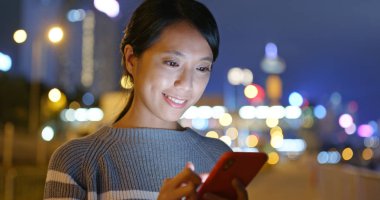 Geceleri Asyalı kadın cep telefonu kullanıyor