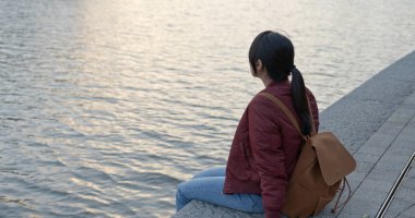 Nehir kenarında oturan kadın