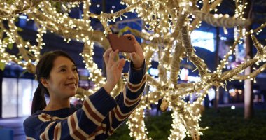 Kadın Noel gecesi cep telefonu ile fotoğraf çekmek