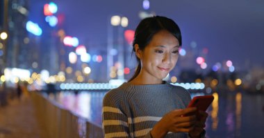 Kadın iş üstünde hareket eden telefon City geceleri