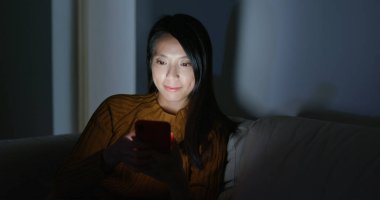 Smartphone kullanımı kadın gece kanepede oturup