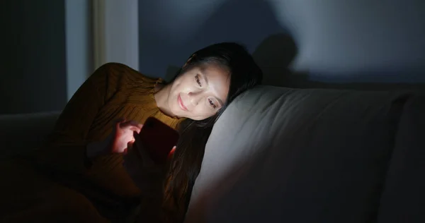 Γυναίκα Χρήση Κινητού Τηλεφώνου Και Ξαπλωμένος Στον Καναπέ Νύχτα — Φωτογραφία Αρχείου