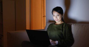 Evde dizüstü bilgisayar üzerinde genç kadın çalışma