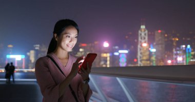 Kadın geceleri cep telefonunu kontrol ediyor.