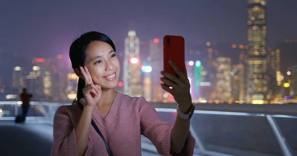 女性は 夜香港市内で携帯電話で写真を撮る — ストック写真