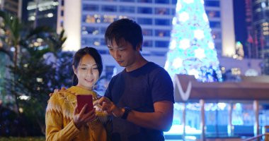 Çift gece Noel ağacı dekorasyon ile cep telefonu selfie almak
