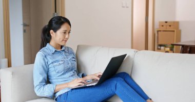 Bilgisayar üzerinde kadın çalışması ve evde kanepede oturmak