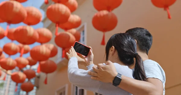 赤いランタンで写真を撮るための携帯電話のカップルの使用 — ストック写真