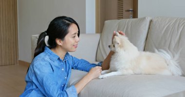 Kadın evde onu Pomeranian köpeği kucaklamak