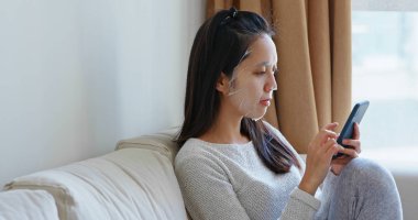 Kadın uygulama yüz maskesi ve cep telefonu evde kullanımı