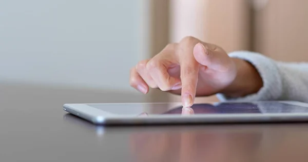 Woman finger touch on tablet computer at home