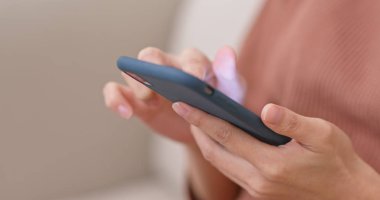 Evde cep telefonu kullanan bir kadın