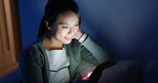 Asian woman look at cellphone and sit on couch